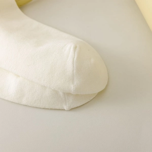 Macro shot of precise toe seam stitching on high-quality white cotton knitted socks
