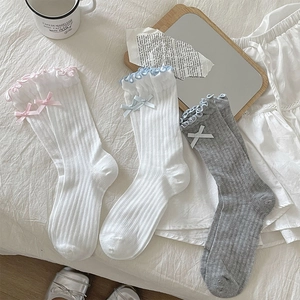 Detailed close-up of cute ballet-style socks with lace edges and ribbon bow accents