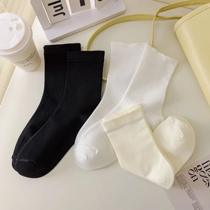 Close-up of ribbed cotton crew socks in black, white and beige for a minimalist look