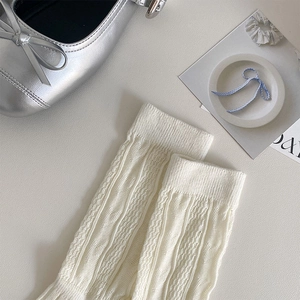 Close-up of white ribbed knit crew socks with a stylish silver Mary Jane flat shoe
