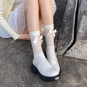 Détail de chaussures Mary Jane blanches à plateforme avec brides croisées et nœud en soie