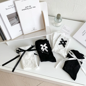 Detail of JK style knit socks featuring satin bows and lace trim in a flat lay setup