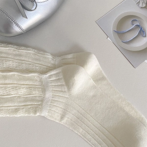 Detail of beige mesh knit socks showing fine hollow texture and ribbed reinforced heel
