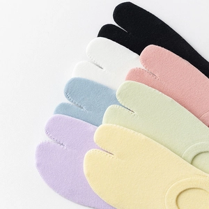 Détail de chaussettes Tabi multicolores en coton montrant la maille fine et l'orteil séparé