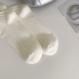 Close-up of white breathable mesh ribbed knit socks with fine vertical stripe texture