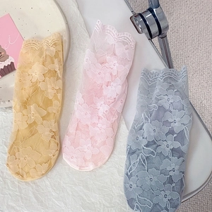 Flat lay of floral lace crew socks in pastel yellow pink and blue for women