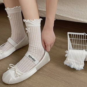 Detailed view of white mesh crew socks with ruffle trim and cute side bows