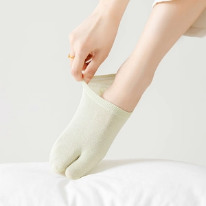 Gros plan de chaussettes tabi beige montrant la texture côtelée en coton et l'élasticité