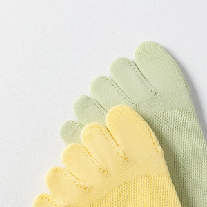 Macro detail of breathable mesh texture on yellow and green cotton five-toe socks