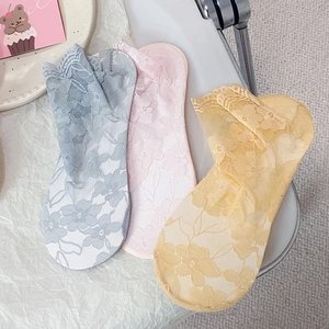 Close-up of lace mesh socks in light blue, pink, and yellow with floral embroidery