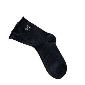 Black knit crew socks with colorful nep texture and white bow embroidery on white background