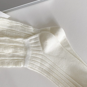 Gros plan de chaussettes en tricot blanc avec rayures et détails de dentelle