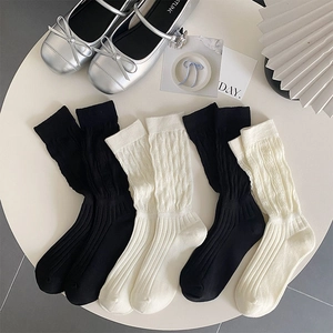 Close-up of knitted crew socks in black and cream with stylish ribbed texture and slouchy cuffs