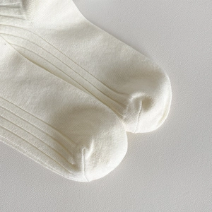 Gros plan sur la texture en tricot côtelé blanc et les coutures de qualité des chaussettes