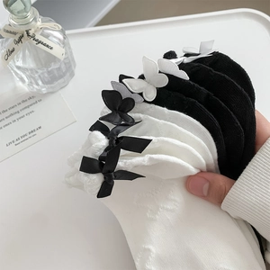 Detail of white and black JK style socks with bows and butterflies in a tray