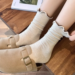Japanese style frilly cotton crew socks in beige with brown lettuce edge on wooden background