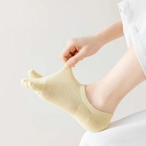 Detailed view of elastic yellow mesh five-finger socks with breathable fabric texture
