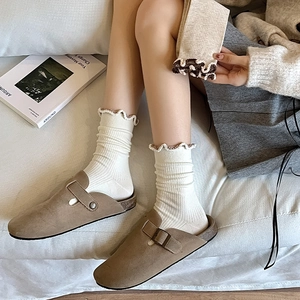 Japanese style khaki suede mule slippers with white ruffled socks in a cozy home setting