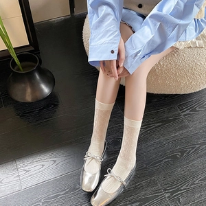 Detail of off-white mesh crew socks with vintage argyle pattern and ribbed cuffs