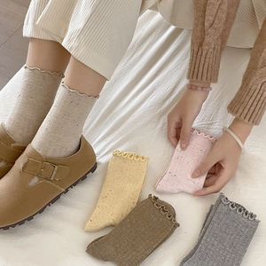 Close-up of frilly edge socks with color speckled texture in assorted pastel colors