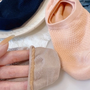 Detail of wave silicone non-slip heel strips on breathable mesh cotton liner socks