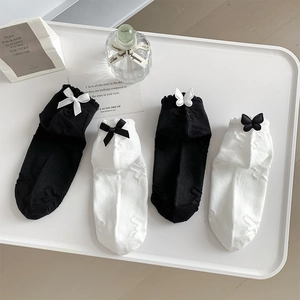 Detail of JK style ankle socks with 3D bows and butterfly patterns on a white tray