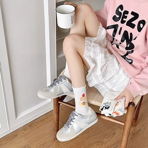 Detail of white cotton crew socks with sweet cake embroidery and ruffled cuff design