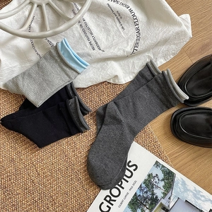 Detailed texture of ribbed cotton crew socks in dark grey, black and light blue accents