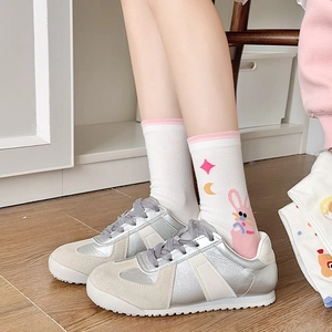 Close-up of white cotton socks with cute pink rabbit and star patterns on the side