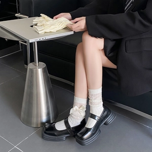 Détail de chaussettes en dentelle blanche avec nœuds et chaussures Mary Jane à plateformes
