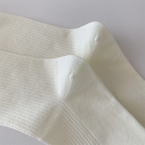 Close-up of white ribbed knit socks showing soft texture and delicate vertical patterns
