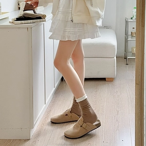Detail of khaki suede mule shoe and brown knit sock with white ruffle lace trim edge