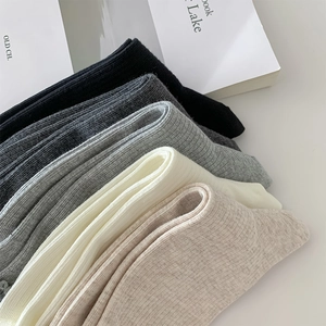Close-up of five pairs of ribbed cotton socks in neutral tones with wood ear edges