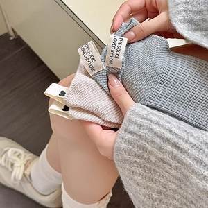 Dettaglio di calze in maglia con etichetta in tessuto e piccolo cuore