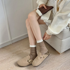 Detail of knitted mid-calf socks with delicate white lace trim in earthy brown tones