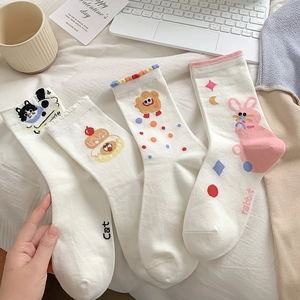 Detail of four pairs of white cotton socks featuring cute cartoon cat, bear and rabbit embroidery
