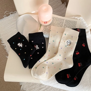 Dettaglio di quattro paia di calzini in cotone con pois colorati e ricami di animali