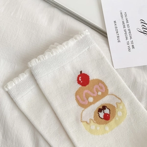 Close-up of white cotton socks with lettuce edge trim and a cute cartoon cupcake pattern