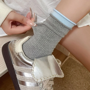 Gray and light blue contrast ribbed crew socks showing high elasticity and soft cotton texture