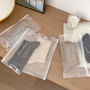 Five-pair set of ruffled cotton crew socks in neutral tones with matte zipper pouches