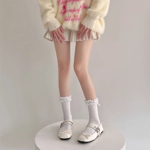 Dettaglio di calzini in pizzo Lolita con fiocco e scarpe Mary Jane beige in stile JK