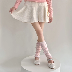 Detail of pink knitted leg warmers with bows and ruffled balletcore design layers