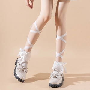 Close-up of cream Lolita platform shoes with bow details and lace socks with ribbons