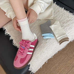 Detail of pink suede sneakers paired with five colors of ribbed crew socks for women