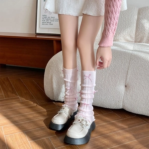 Pink knitted leg warmers with ribbon bows paired with off-white platform shoes
