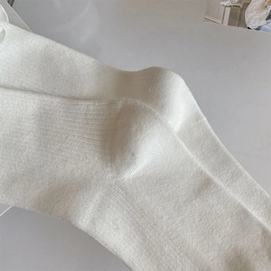 Dettaglio della trama in maglia a costine bianca e della cucitura sul tallone dei calzini
