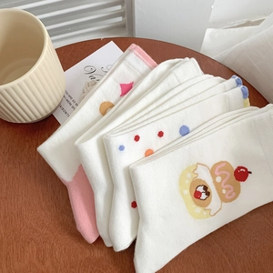 Close-up of white cotton socks with cute donuts and polka dots on a wooden table