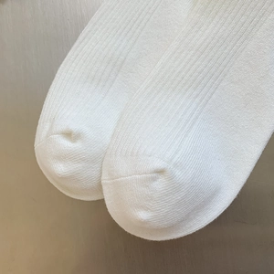 Dettaglio di calze a coste bianche in maglia con trama in cotone di alta qualità e cuciture
