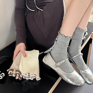 Detailed view of grey ruffled cotton socks with vertical ribbed knit and wavy edge trim