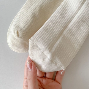 Detailed macro view of off-white ribbed cotton socks with fine stitching on the toes